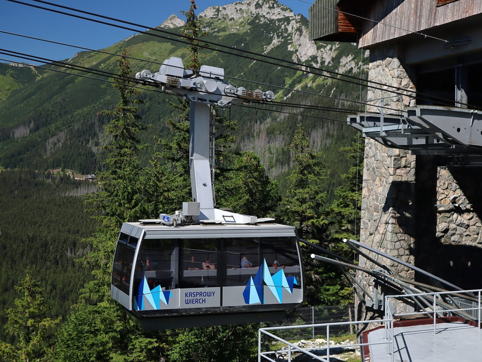 A Kasprowy Wierch cable car cabin leaving the Myślenickie Turnie station, with Tatra peaks behind