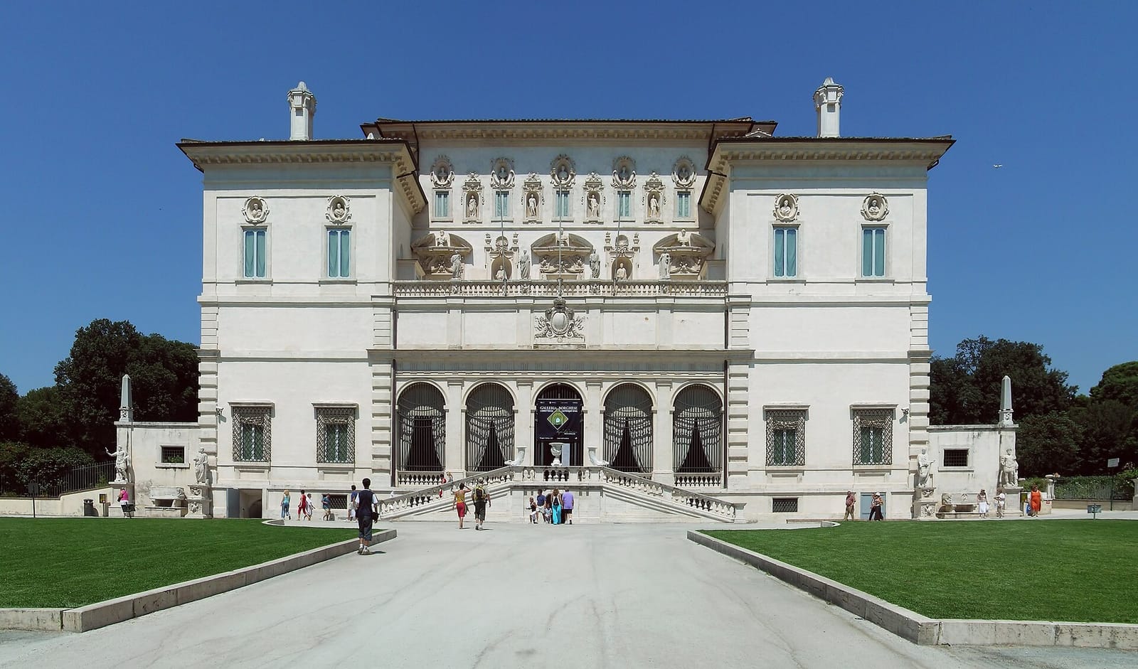 The front facade of the Borghese Gallery beneath a blue sky