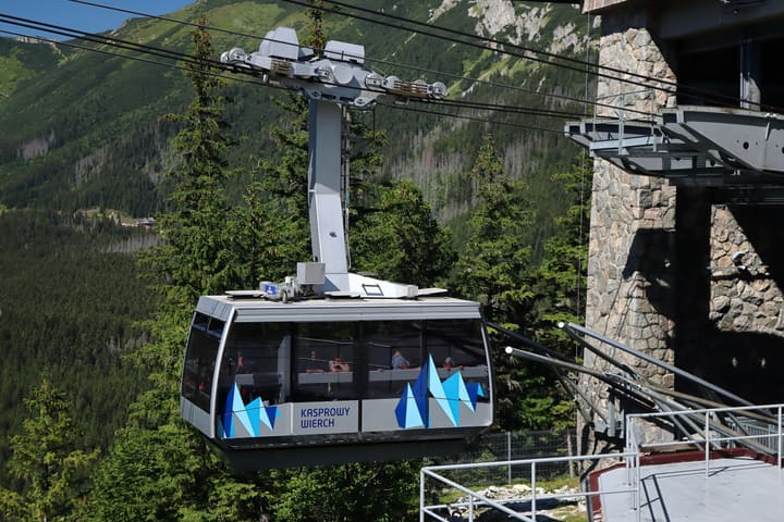 A Kasprowy Wierch cable car cabin leaving the Myślenickie Turnie station, with Tatra peaks behind
