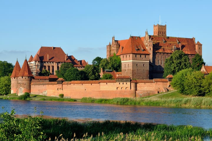 Malbork Castle's brick Gothic walls and towers above the Nogat river